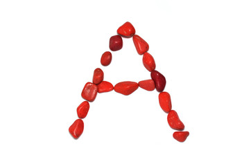 Alphabet in red pebbles on white background