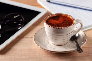 Digital tablet and coffee cup on wooden table