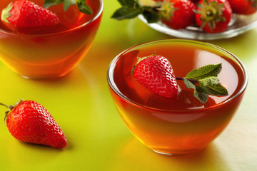 Fruit jelly with strawberries on a green table