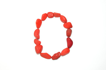 Alphabet in red pebbles on white background