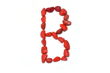 Alphabet in red pebbles on white background