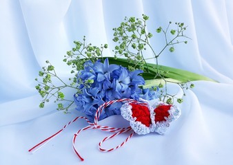 Handmade crocheted butterfly on white background and red and white string, known as Martisor. It is...
