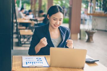 Asian businesswoman is sitting at a coffee shop with a bright face.