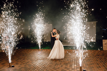 Wedding fireworks. Wedding couple bride and groom dance during a fire show. Full-length photo at night