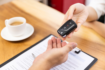 Car loan, contract agreement,buying and rent car concept, Saleperson holding car key on hand