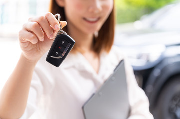 Car loan, contract agreement,buying and rent car concept, Saleperson holding car key on hand