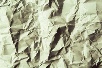 A crumpled paper background. Light green color.