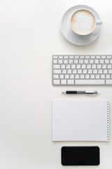 White workplace. Cup of coffee, keyboard, pen, notebook and phone. Copy space. Knolling.