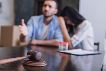 Selective focus of worried bankrupts at table with gavel in room