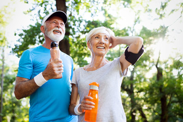 Beautiful mature couple jogging in nature living healthy