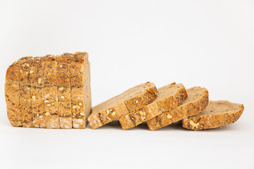 Soft sliced cereal bread with oatmeal and seeds. Pieces of brown loaf laying together isolated on...
