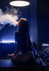 Young sexy woman is vaping. A cloud of vapor. Vape.