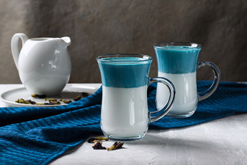 Latte Matcha Dalgona. Hot fresh milk with blue butterfly pea flowers. On a light gray background. Horizontal orientation