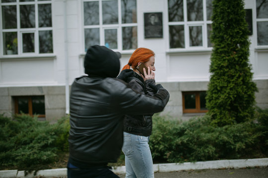 Young woman gets phone snatching on the street , Beware of mobile phone snatching thief, robbery on the street, soft focus