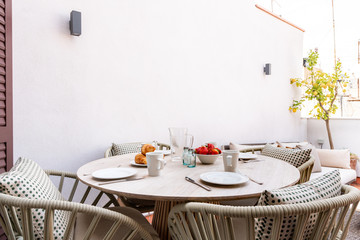Breakfast with oranges, fruits, croissants, cake and coffee, magazine decorated table 