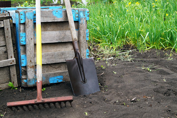 Garden rake and shovel on the background of a wooden, textured box. Garden tools, concept tools. Copying space..