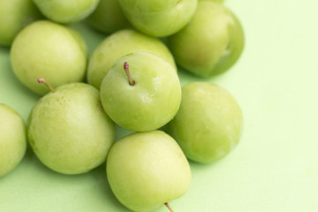 group of green plums on green background