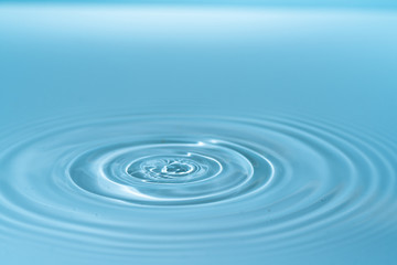 Naklejka na ściany i meble Waves on the surface of the water from a collision. Drop of water drop to the surface.
