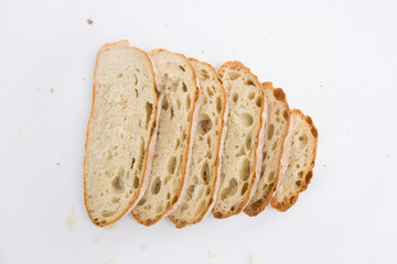 Freshly baked homemade bread sliced for sandwiches with breadcrumbs. Top view, high angle, closeup shot. Isolated object on white background. Fresh food, bakery or breakfast concept