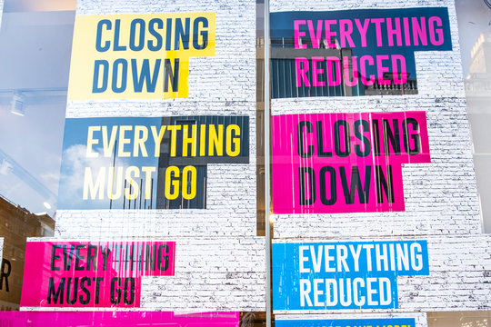 Retail store closing down 'reduced, everything must go' signs in shop window
