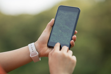Hands using mobile phone in spring nature