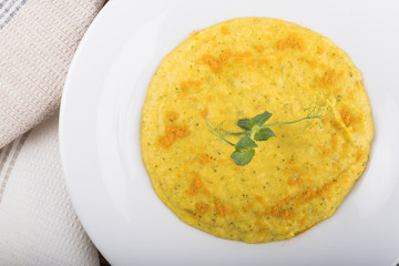 Mixed vegetable cream soup in a white bowl, isolated on a white background, on wooden cutting board