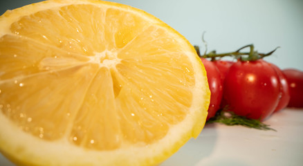 Fototapeta na wymiar Red tomatoes and yellow lemon on the white isolated background. Low angle macro shot