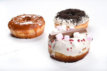 Three melted glazed with dark and white chocolate, marshmallows, biscuit crumbles, caramel sugar