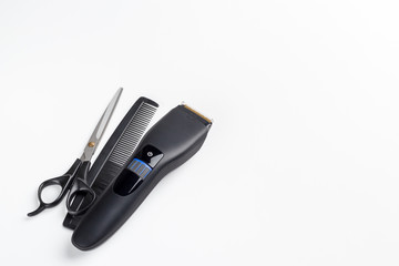 hair clipper, scissors and comb on a white background