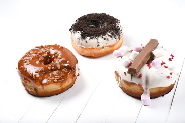 Three melted glazed with dark and white chocolate, marshmallows, biscuit crumbles, caramel sugar