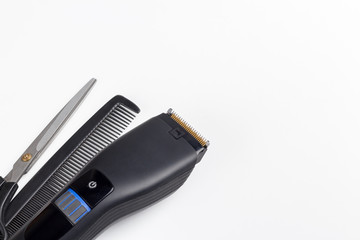 hair clipper, scissors and comb on a white background