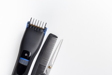 hair clipper, scissors and comb on a white background