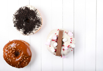 Three melted glazed with dark and white chocolate, marshmallows, biscuit crumbles, caramel sugar