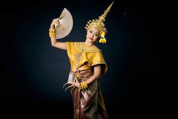 Beautiful Thai woman wearing traditional dancer dress headgear jewelry long nails holding fan...