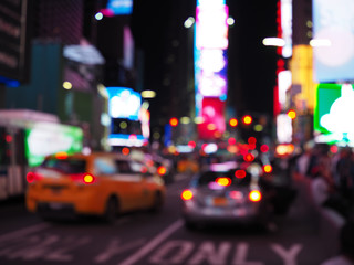 Defocus blur of New York City street scene at night with yellow taxi cabs, cars, lights and...