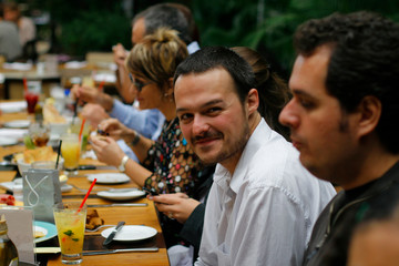 young man smiling at bar table, narrow focus
