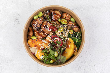 Poke bowl with chicken and vegetables on the white table. - 348542744