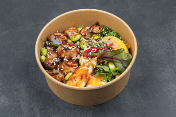 Poke bowl with chicken and vegetables on the white table.
