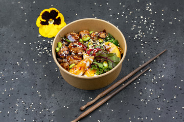 Poke bowl with chicken and vegetables on the white table.