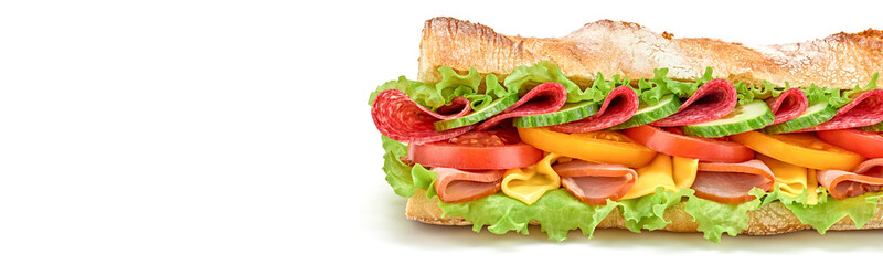 Submarine sandwich with ham, cheese, salami, tomato, lettuce salad, cucumber isolated on white. Homemade baguette sandwich with vegetables. Large sub sandwich closeup, banner