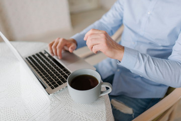 man's hands on the notebook with cup of coffee