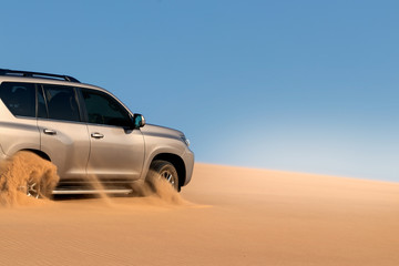 Fototapeta na wymiar Close up of a golden car stuck in the sand in the Namib desert.