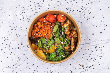 Poke bowl with chicken and vegetables on the white table.