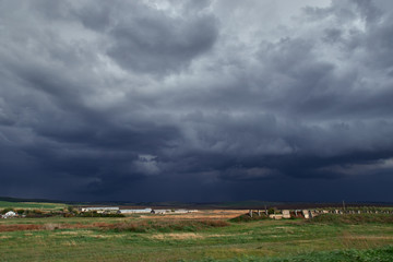 Obraz premium panoramic view of dark thunderclouds above a small village