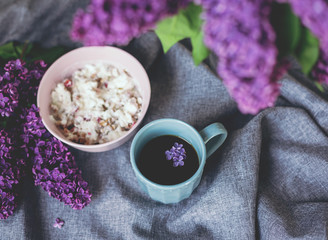 Obraz na płótnie Canvas granola with yogurt. healthy breakfast. cup of coffee with lilac flowers