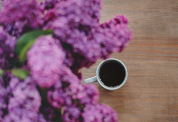 Obraz na płótnie Canvas cup of coffee with lilac flowers