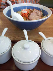 Ramen Dish, Soup Noodle with Japanese Roast Pork on the Table with Seasoning Jars at Front