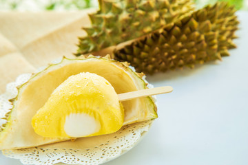 Durian ice cream stick on durian fruit shell on white plate with durian fruit shell blurred blurred...