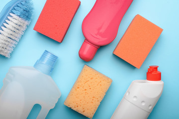 Supplies for spring cleaning on blue background