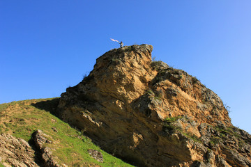 Azerbaijan. 08/04/2018 year. Girl with a scarf on a high rock.